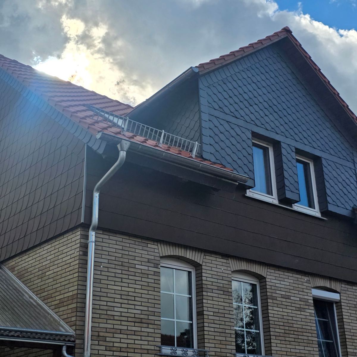 Neue Schieferverkleidung an der Gaube mit Dachrinne und Ziegeleindeckung